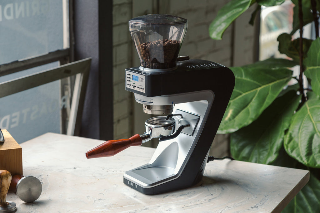 Baratza Sette 270 espresso grinder side view with a walnut wood bottomless portafilter on the portafilter rest lifestyle photo by clive coffee