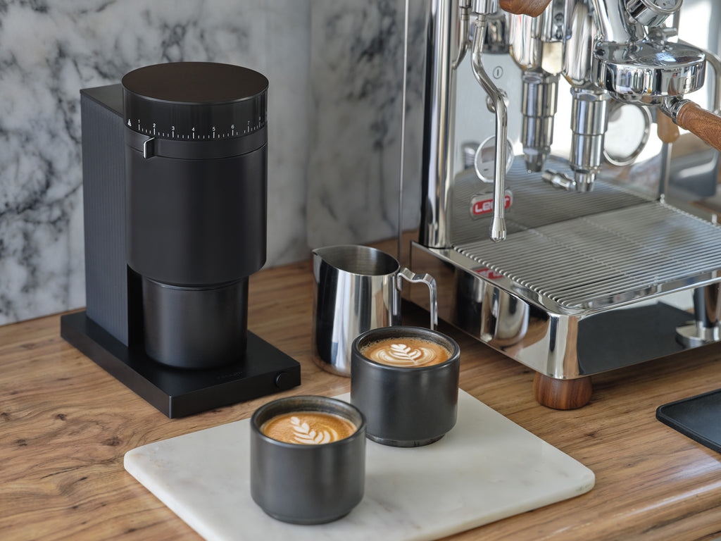 Fellow Opus espresso grinder next to the Lelit Bianca espresso machine with two cortados.