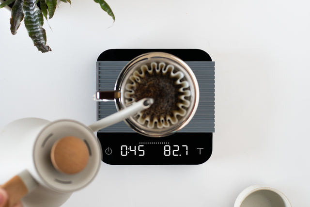 Acaia Pearl Scale in pitch black displaying weight to the tenth of a gram, Clive Coffee - Lifestyle